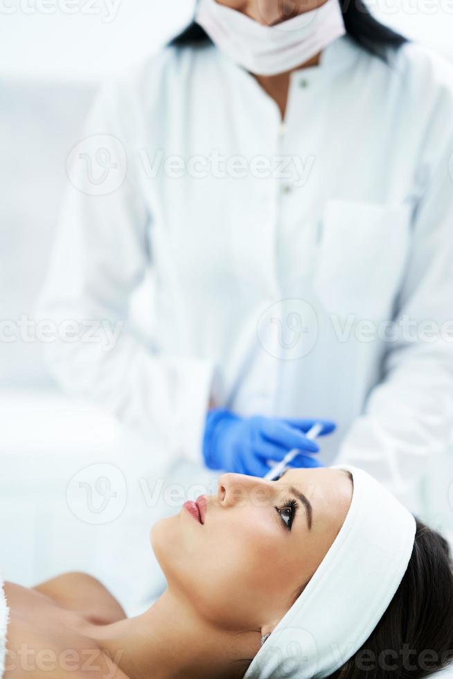 hermosa joven recibiendo tratamiento facial en el salón de belleza. foto