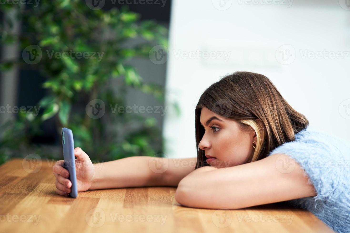 adolescente enviando mensajes de texto en casa foto