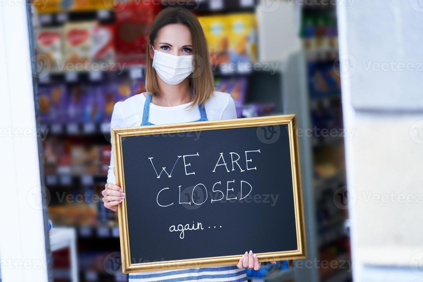 Shop assistant holding announcement board photo
