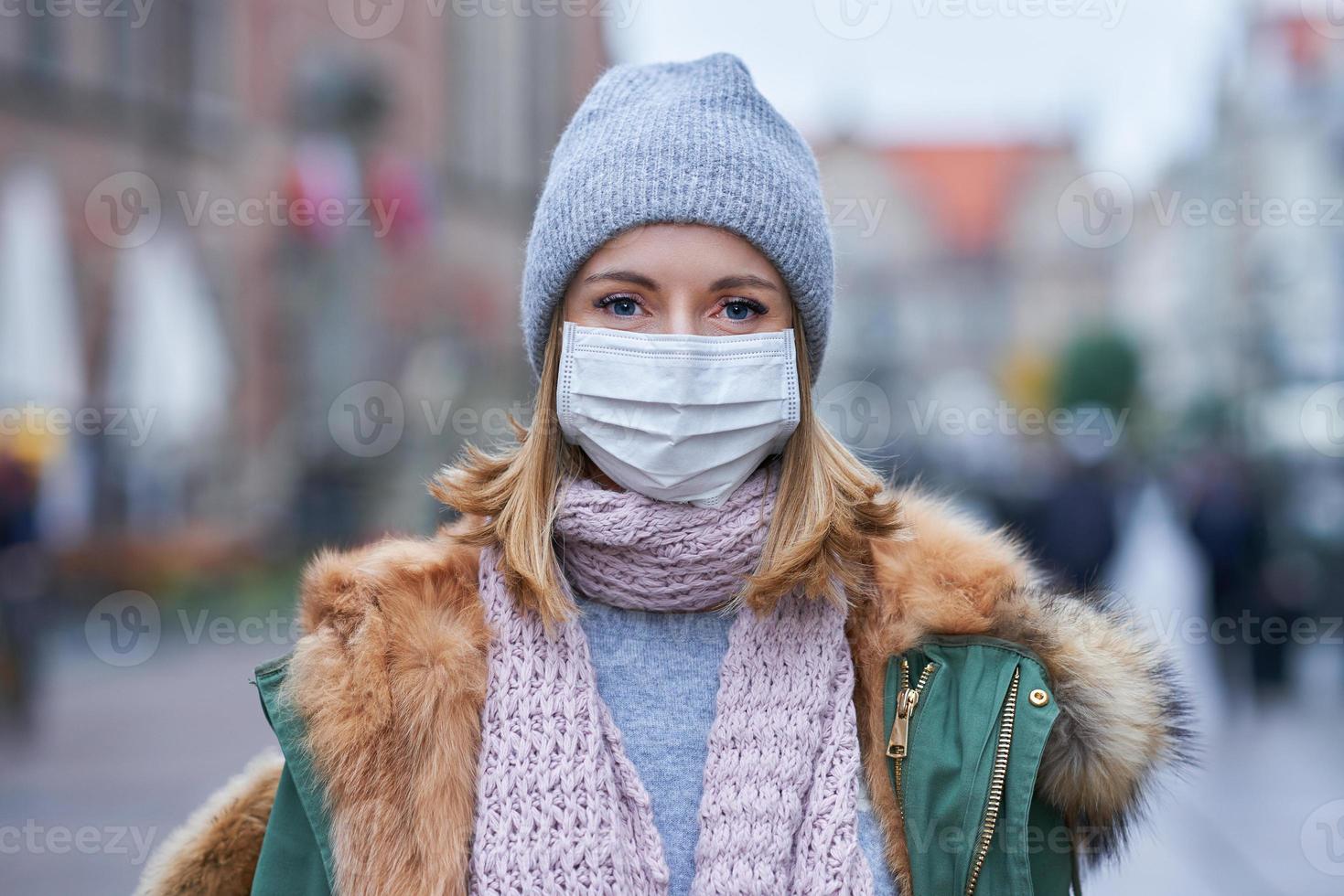 mujer con mascarilla debido a la contaminación del aire o la epidemia de virus en la ciudad foto