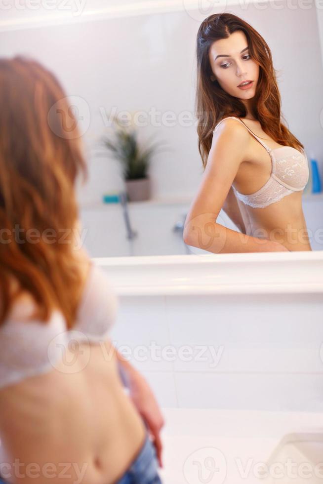 Young woman standing in bathroom in the morning photo