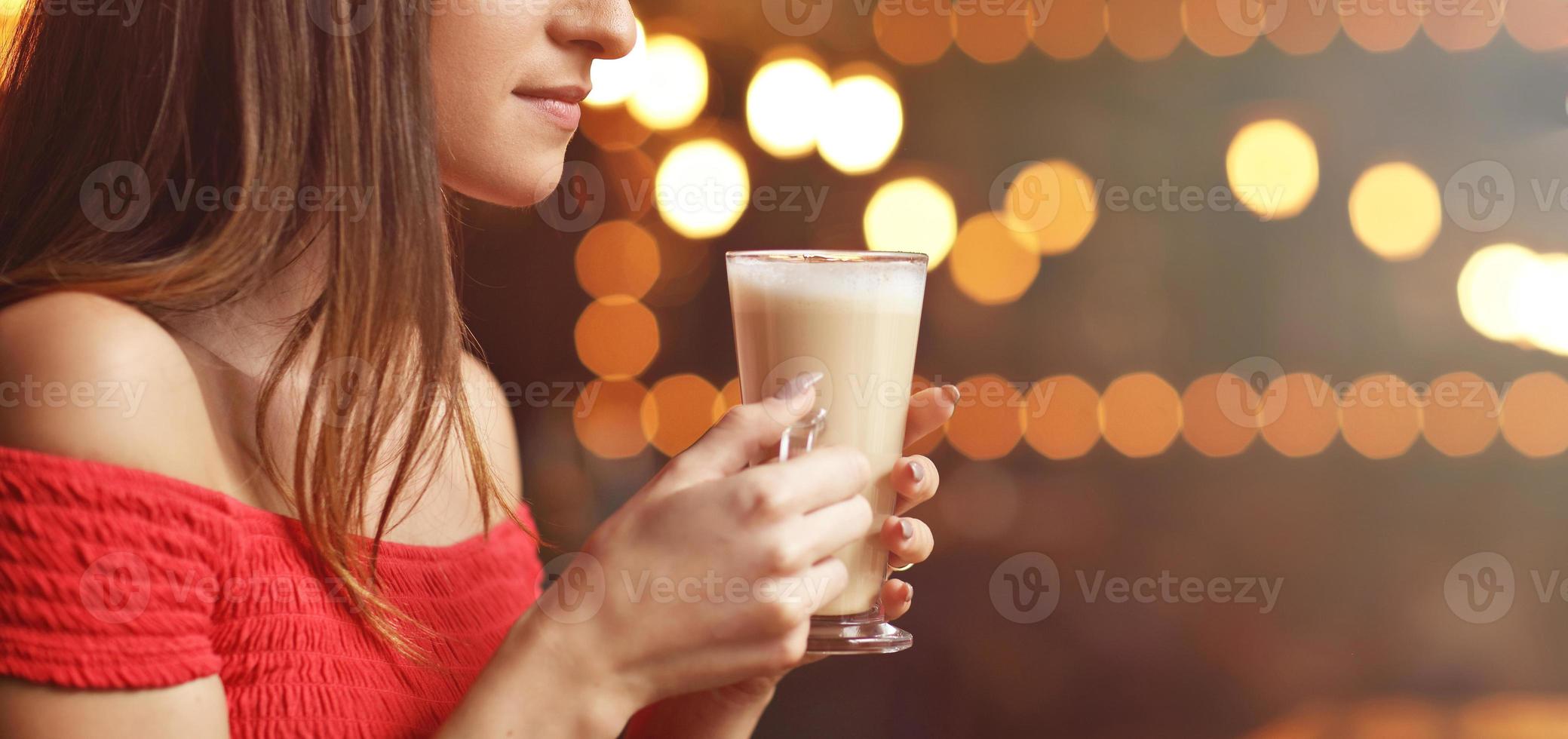 Young woman drinking coffee in a cafe photo