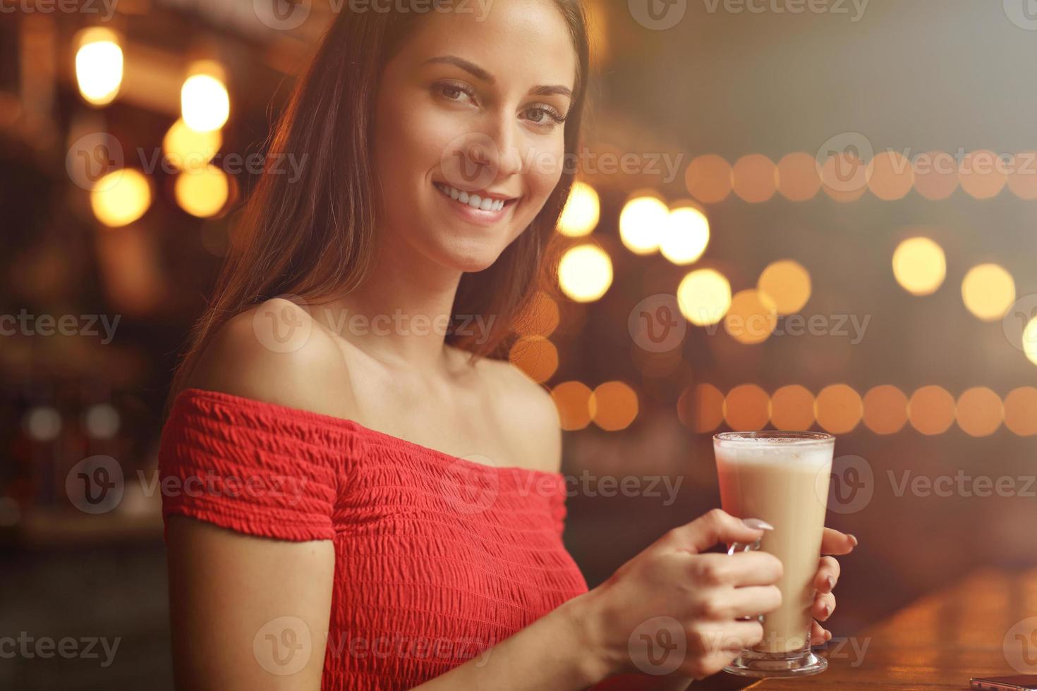 Young woman drinking coffee in a cafe photo