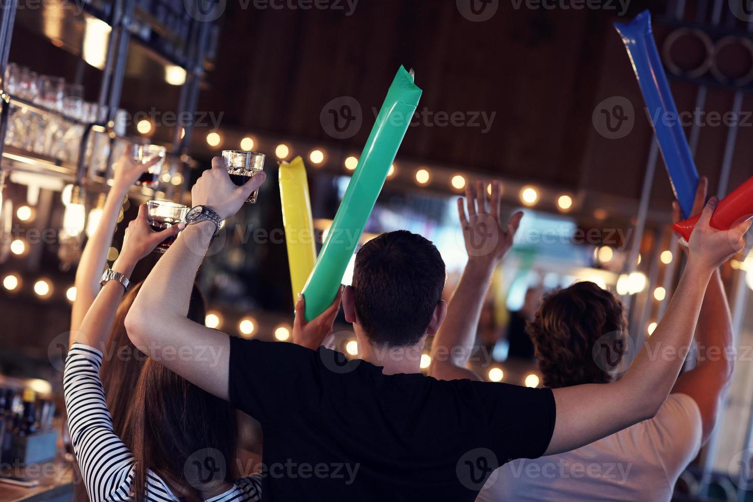 Group of friends watching soccer in pub photo