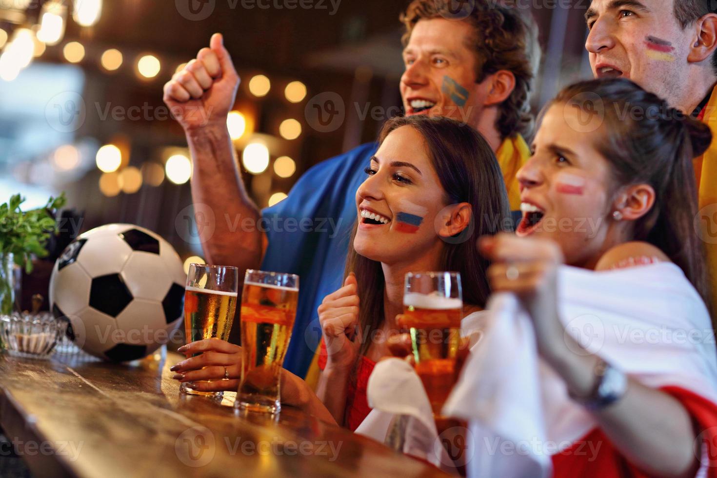 Group of friends watching soccer in pub photo