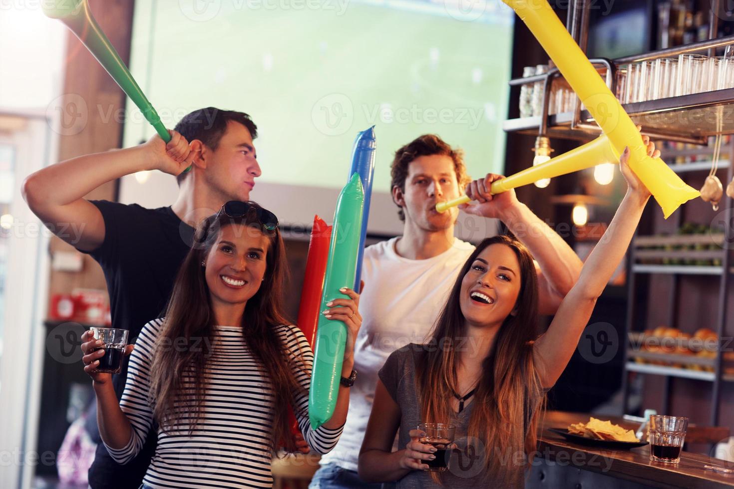 Group of friends watching soccer in pub photo