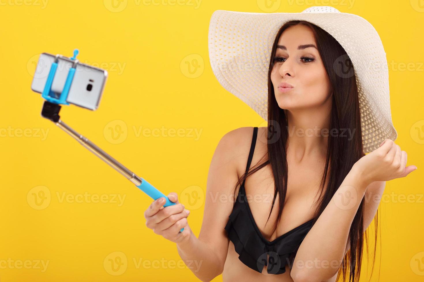 Sexy woman in bikini posing against yellow background photo