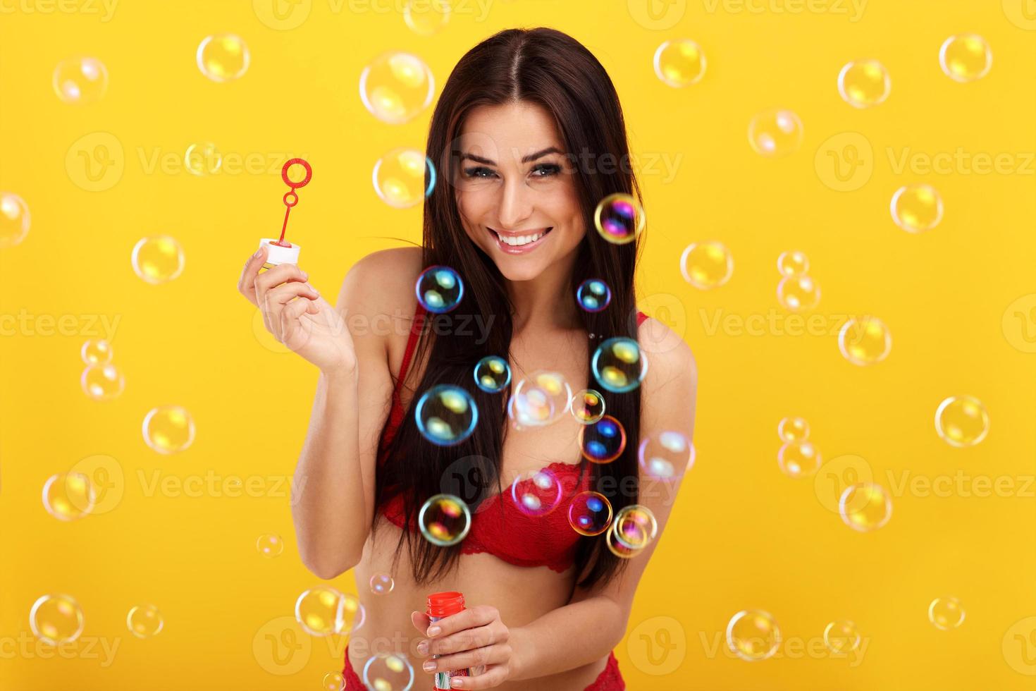 Sexy woman in bikini posing against yellow background photo