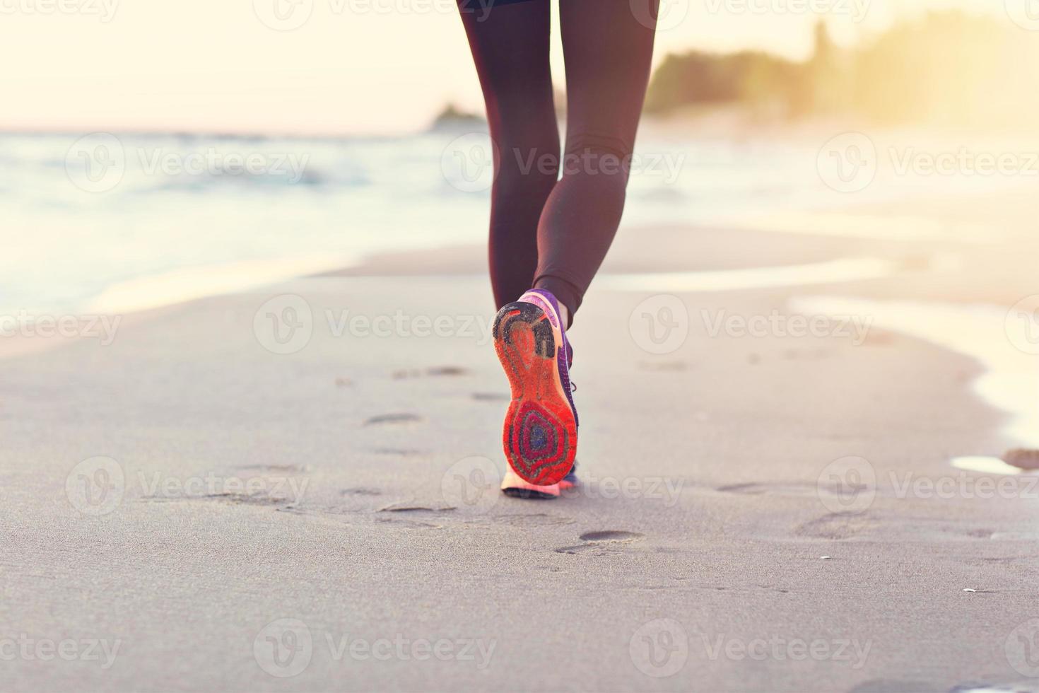 mujer corriendo sola en el hermoso atardecer en la playa foto