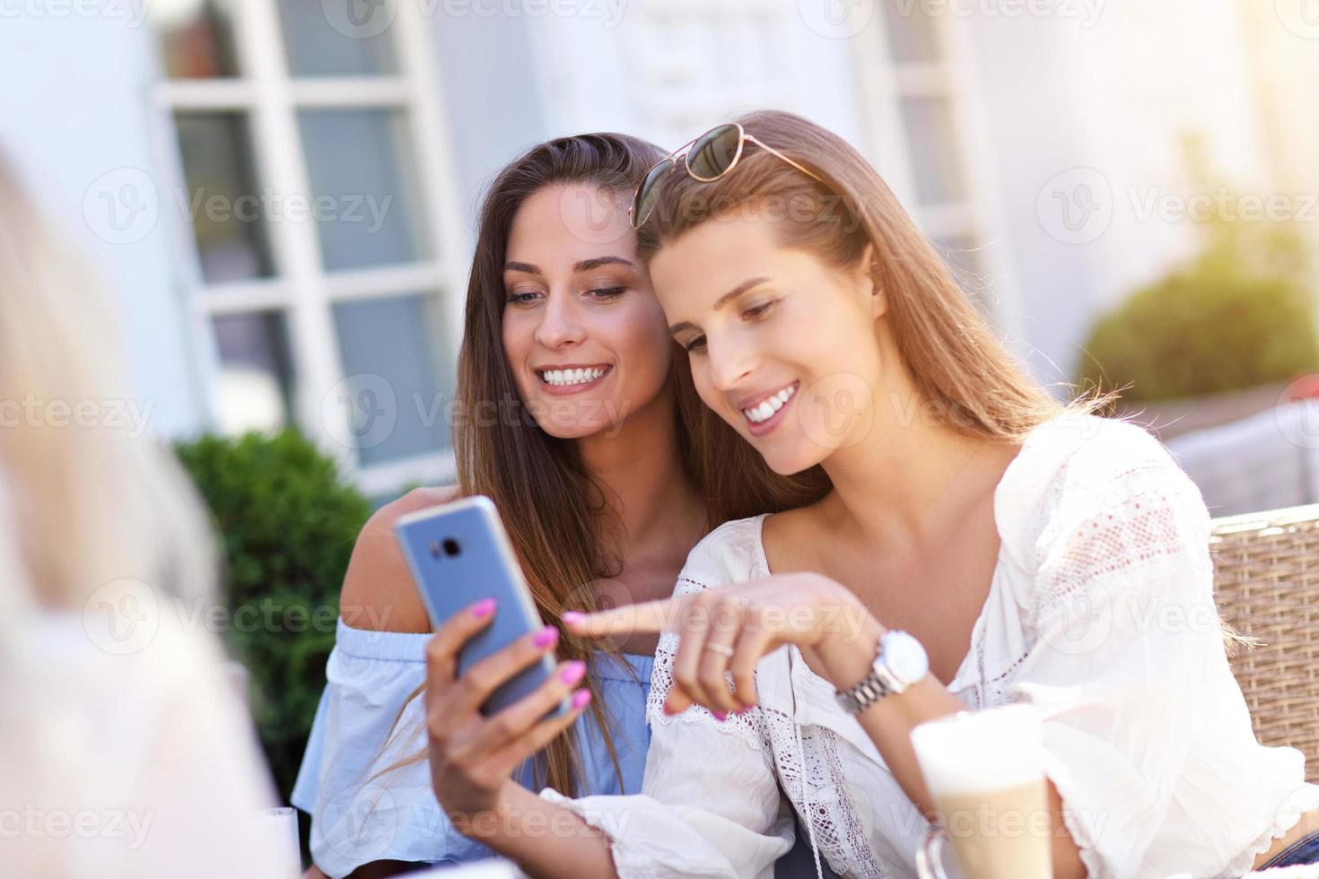 Happy girl friends in cafe during summer time photo