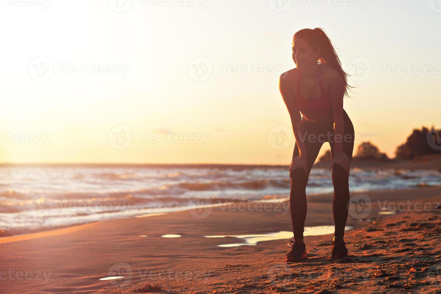 Woman running alone at beautiful dusk on the beach photo