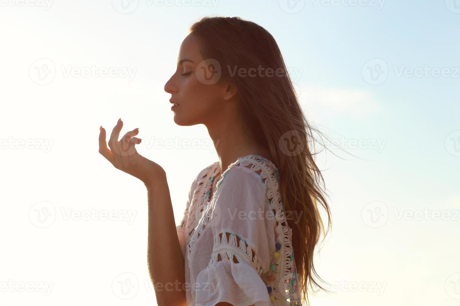 Beautiful calm woman at dusk on the beach photo