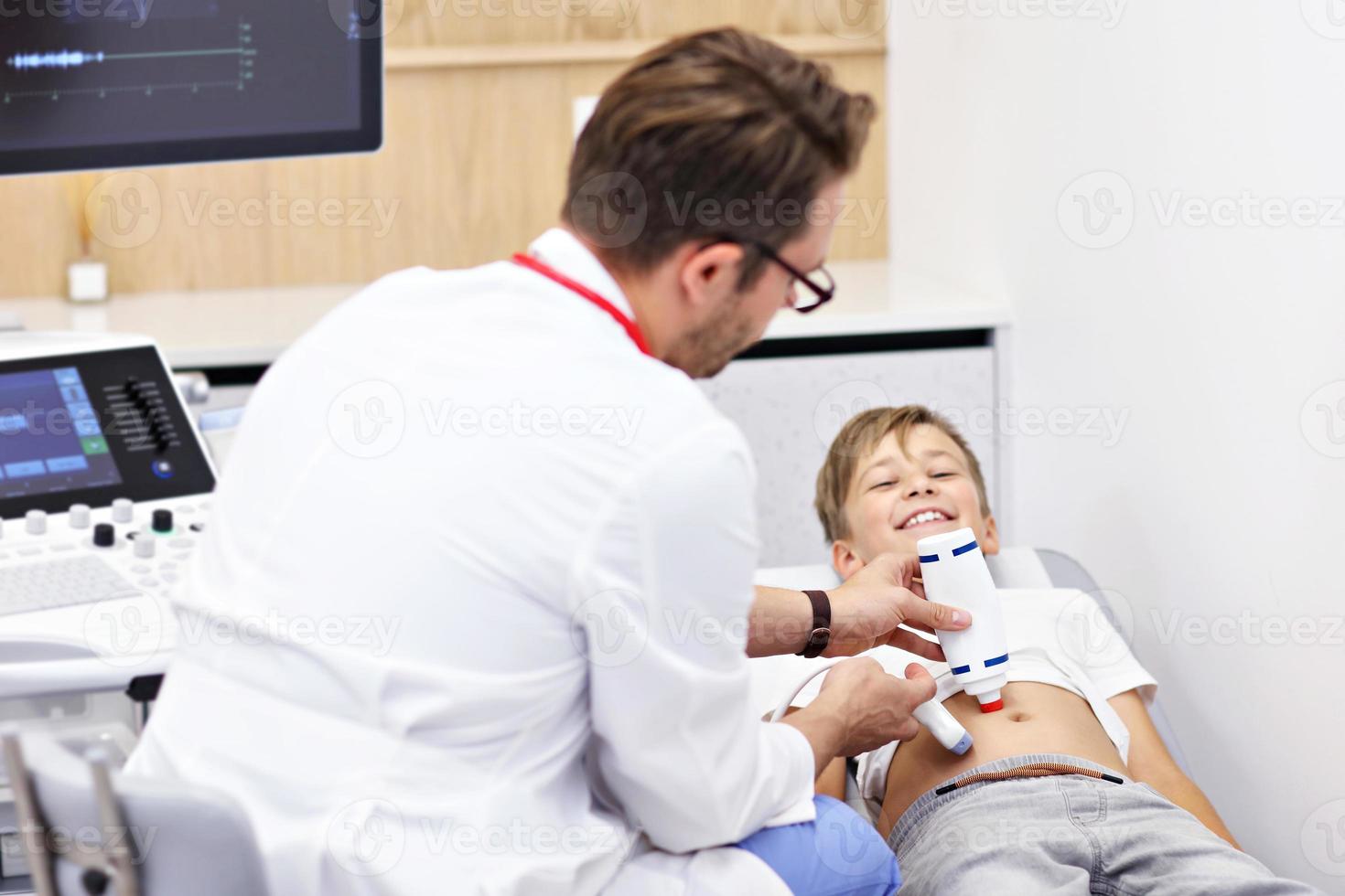 Doctor testing young boy with usg photo