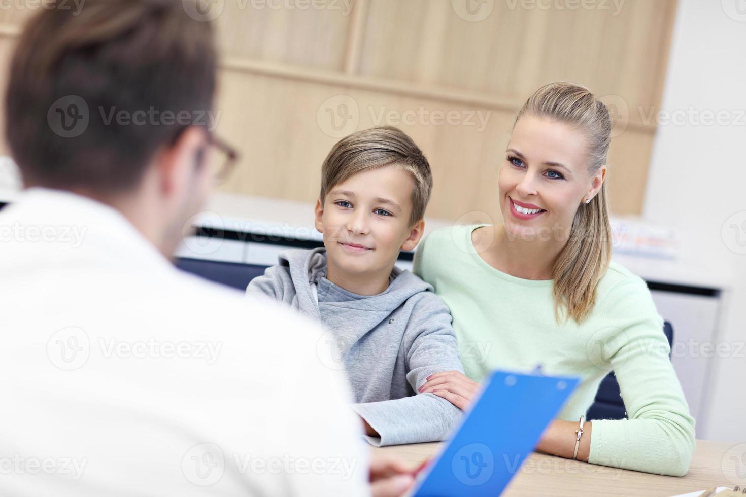 Little boy with mother in clinic having a checkup with pediatrician photo