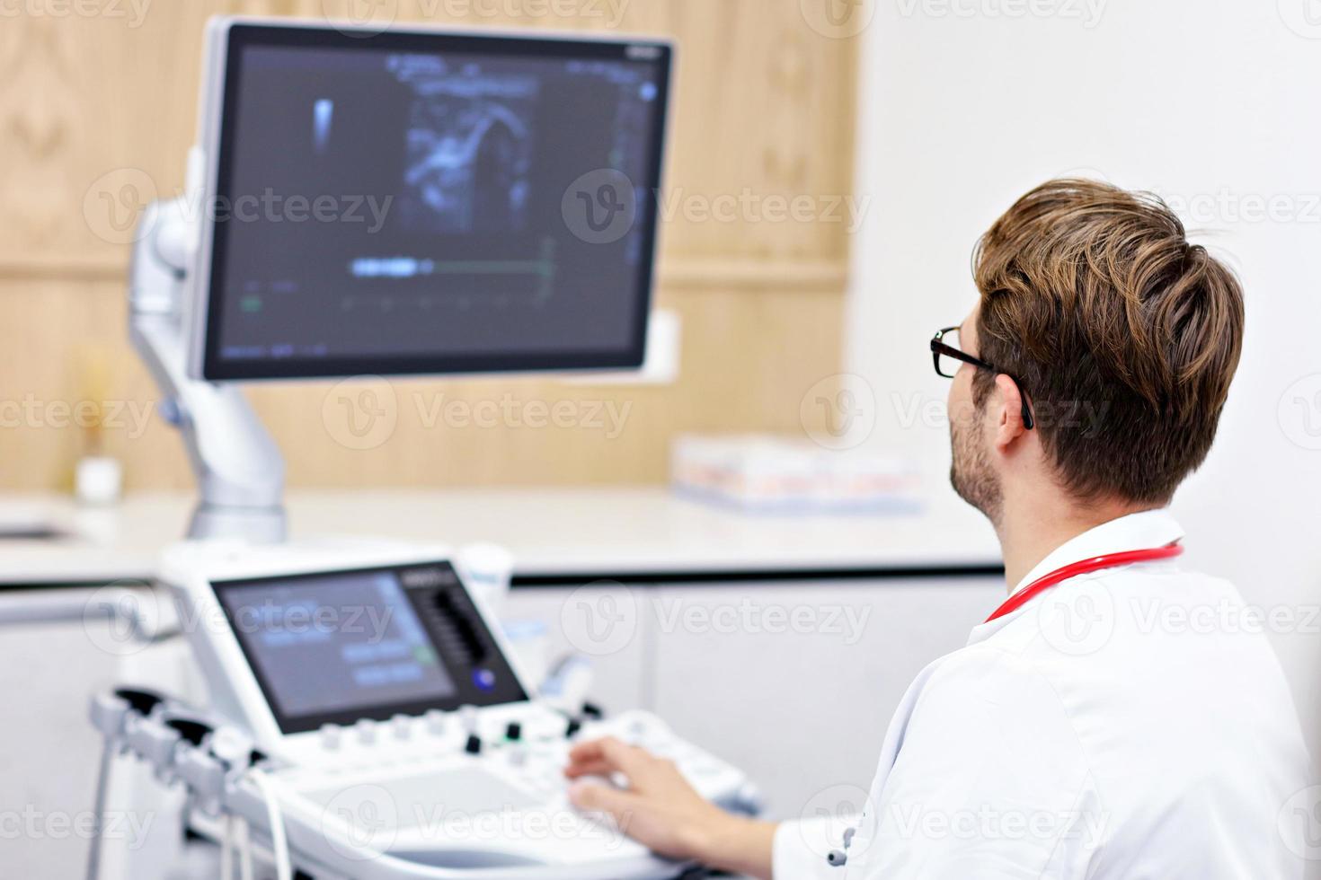 Doctor using ultrasound machine photo