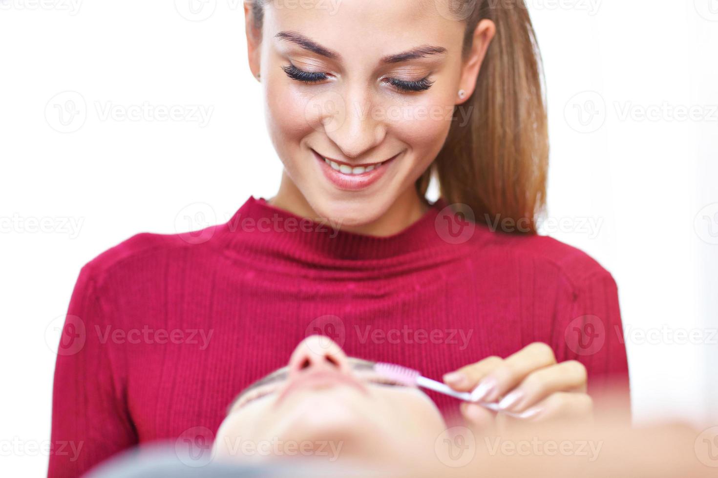 Adult woman having eyelash extension in professional beauty salon photo