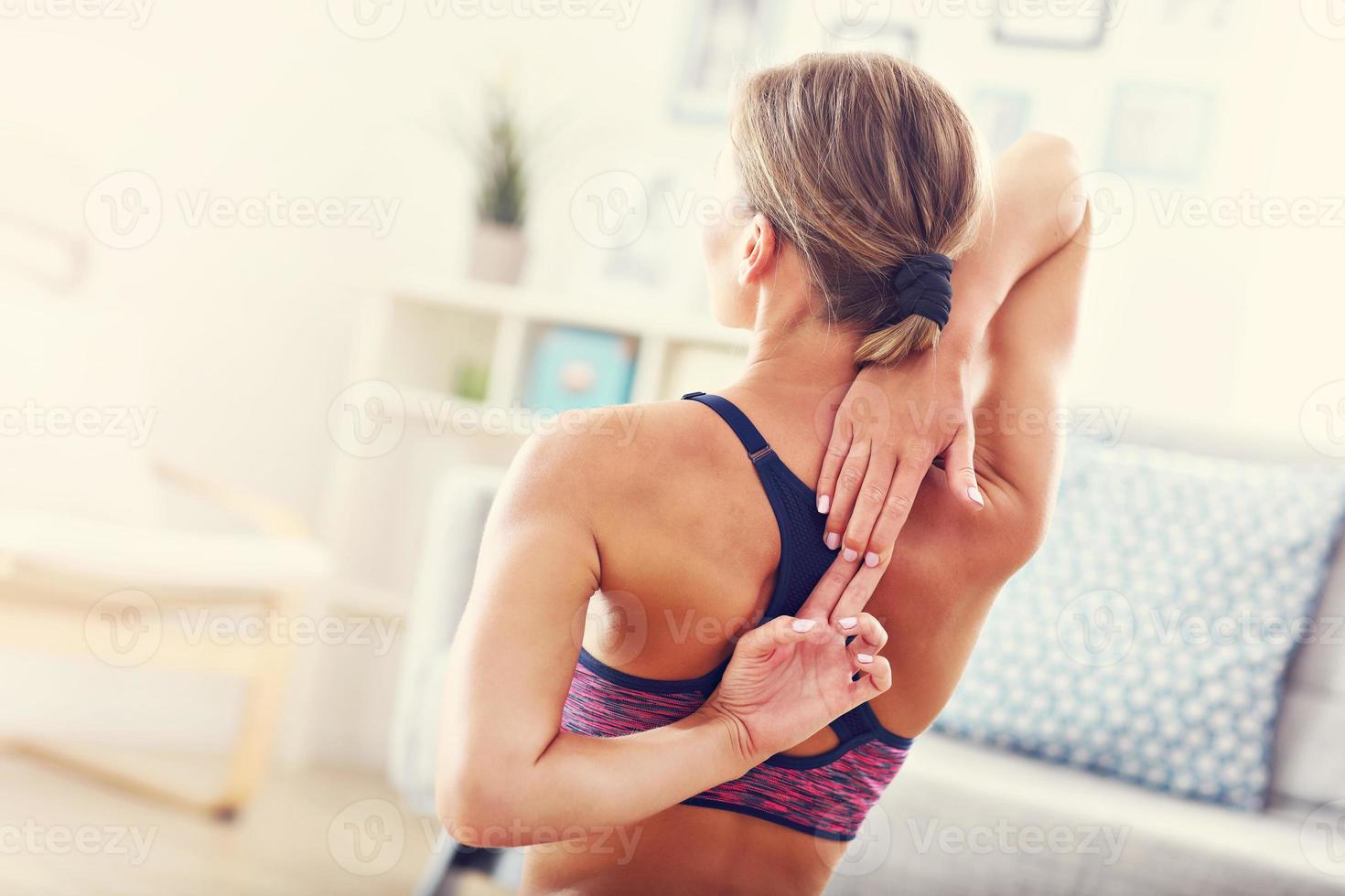 Young woman stretching at home in the morning photo