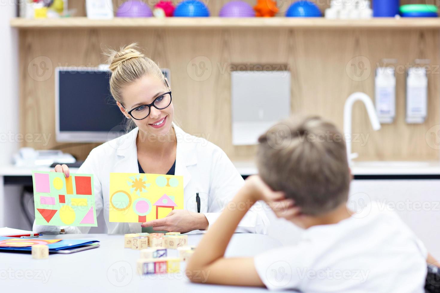 Child psychologist working with young boy in office photo