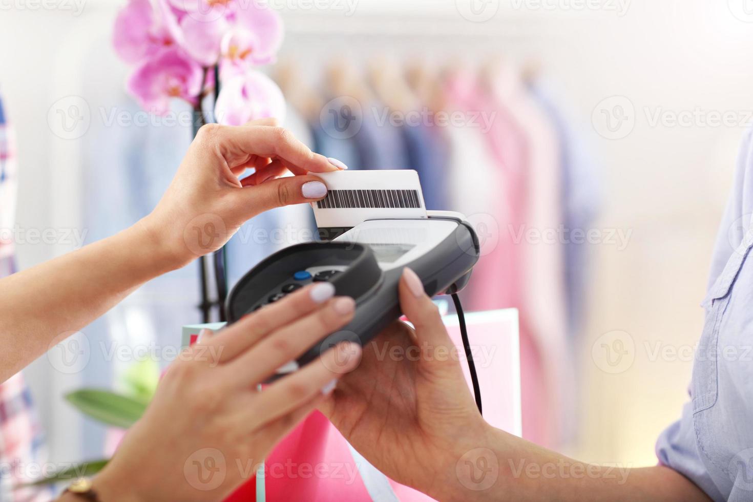 Closeup mid section of female customer paying in shop with credit card photo
