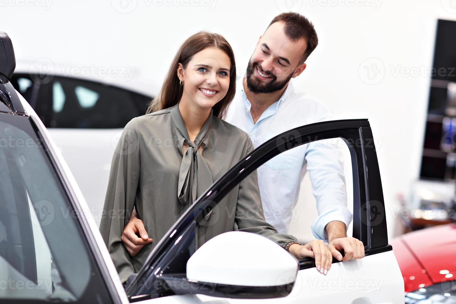 pareja adulta eligiendo auto nuevo en la sala de exposición foto