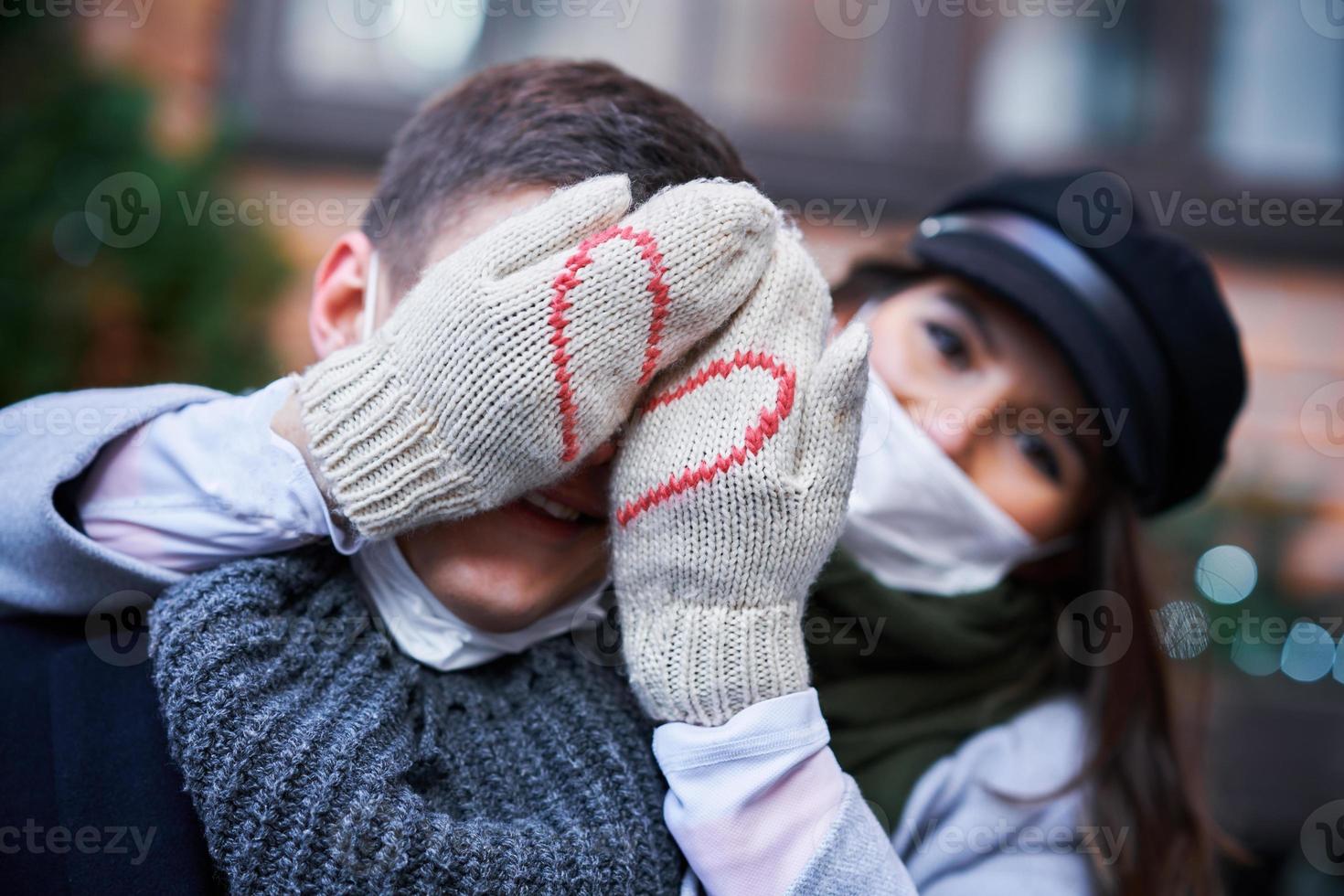 Happy couple celebrating Valentines Day in masks during covid-19 pandemic photo