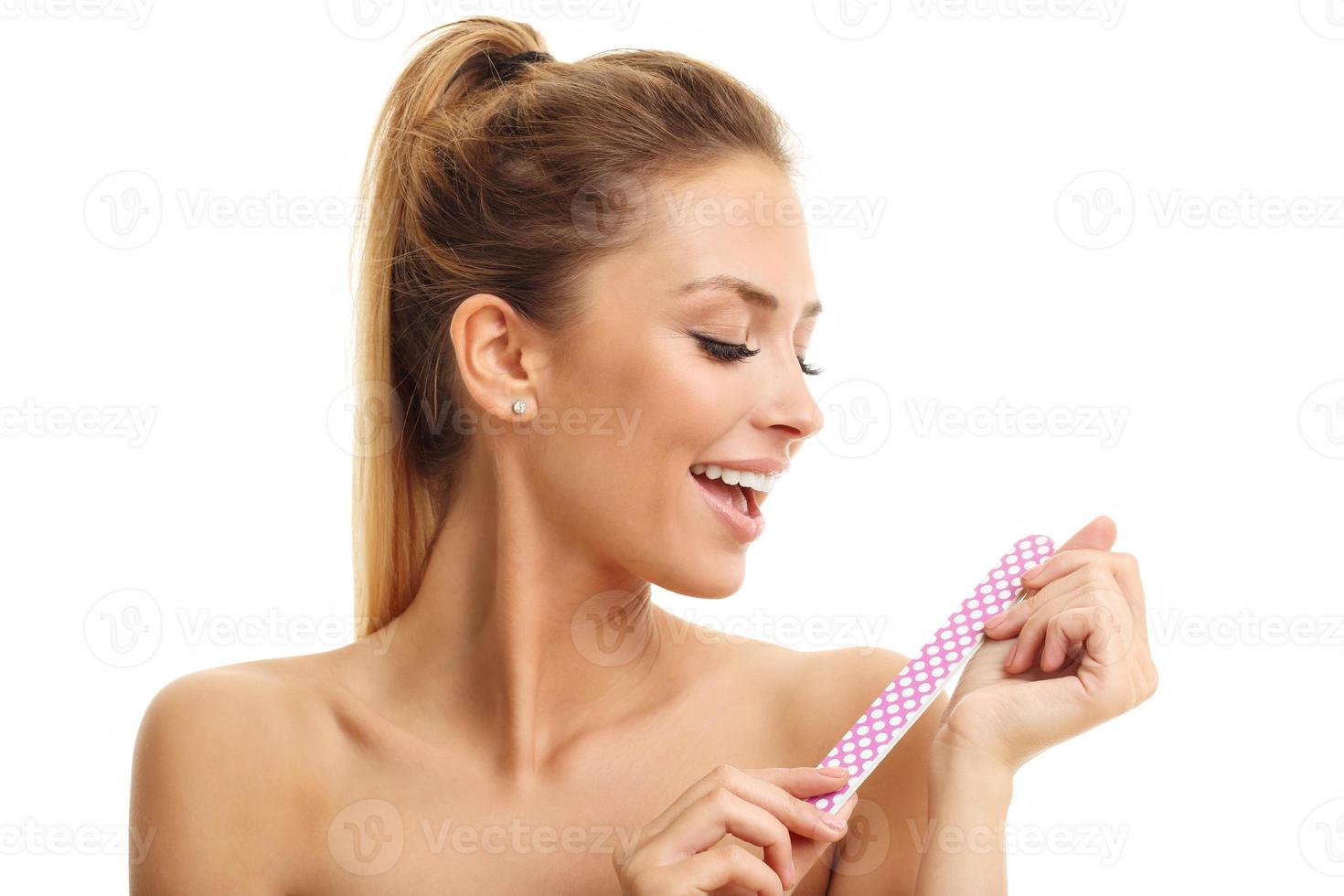 Adult woman polishing fingernails with the nail file photo