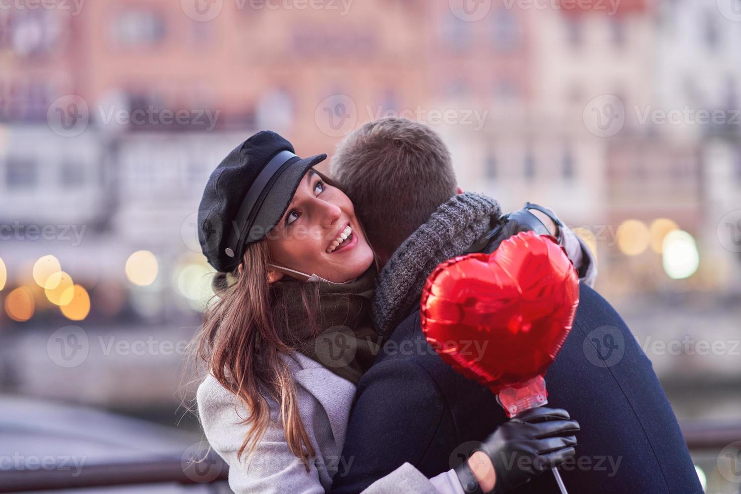 Happy couple celebrating Valentines Day in masks during covid-19 pandemic photo