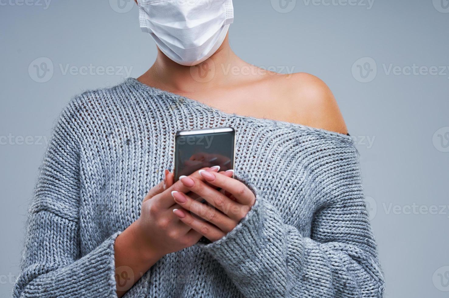 Portrait of beautiful woman in mask on gray background photo