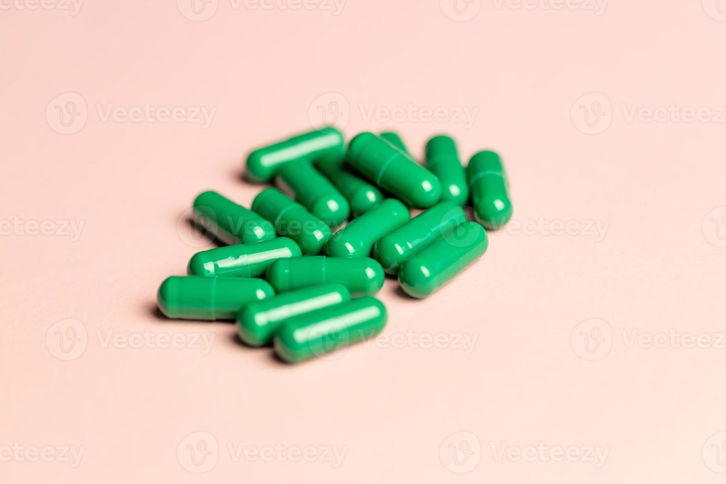 Green capsules on a pink background. photo