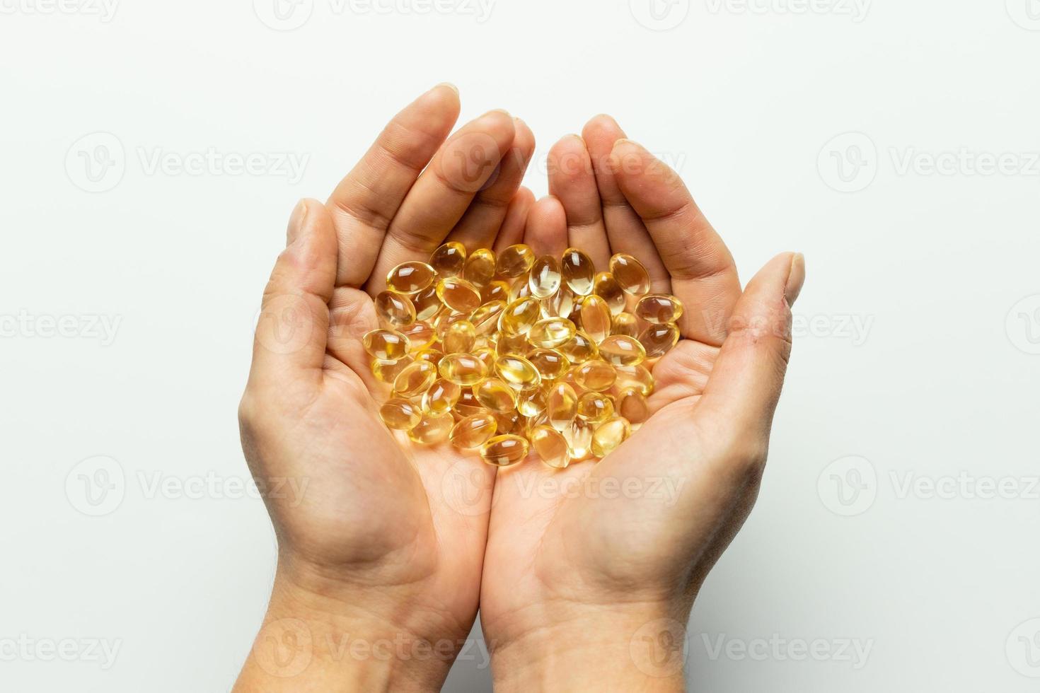 Vitamin D3 capsules on the hands. White background, space for text. photo