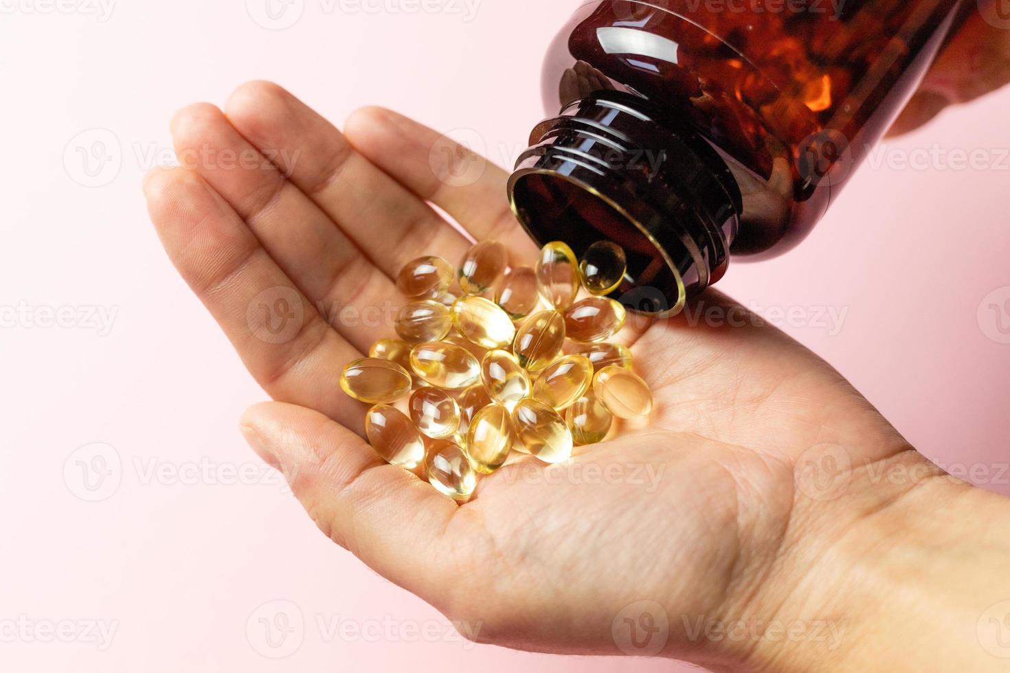 Vitamin D3 capsules poured out of the package. Care for health and immunity. A woman's hand. photo