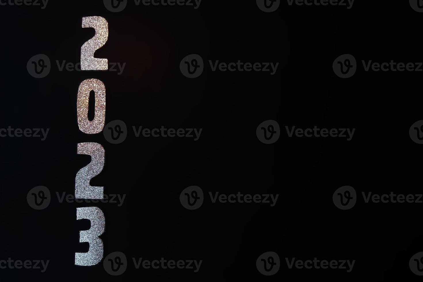Happy New Year 2023. Golden numbers on a black background with glitter photo