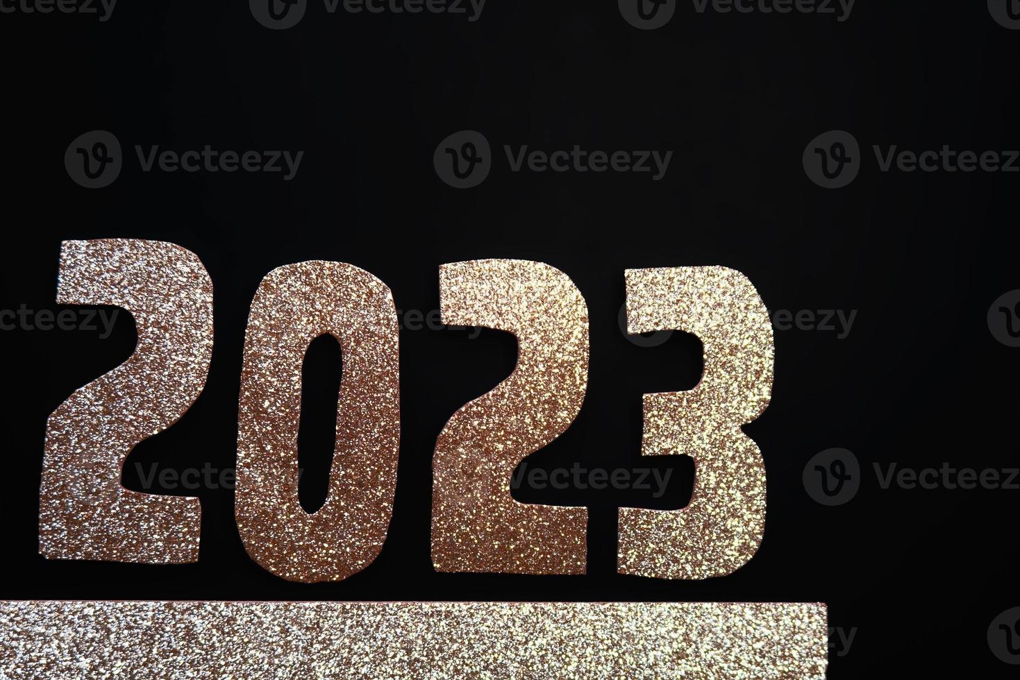 Happy New Year 2023. Golden numbers on a black background with glitter photo