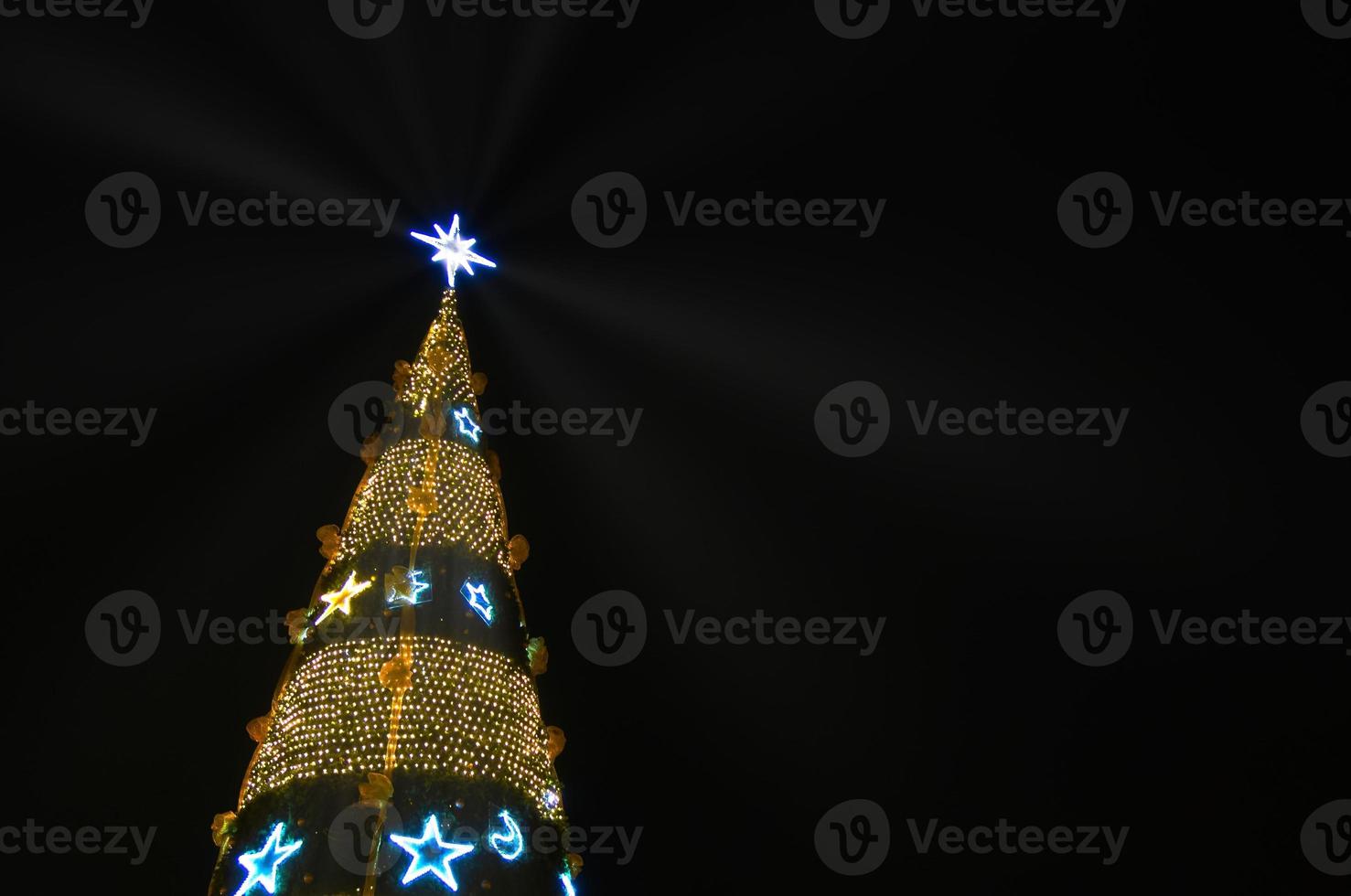 Christmas tree-shaped sparklers on black background photo