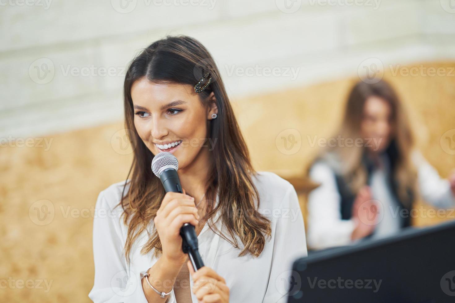 Caucasian woman singing into microphone in studio photo