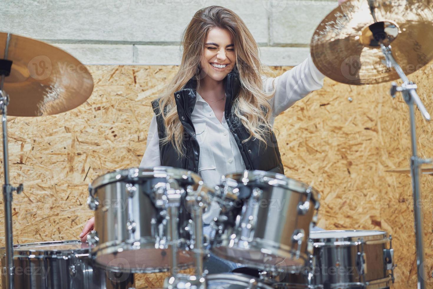 Girl behind drums in a professional recording studio photo