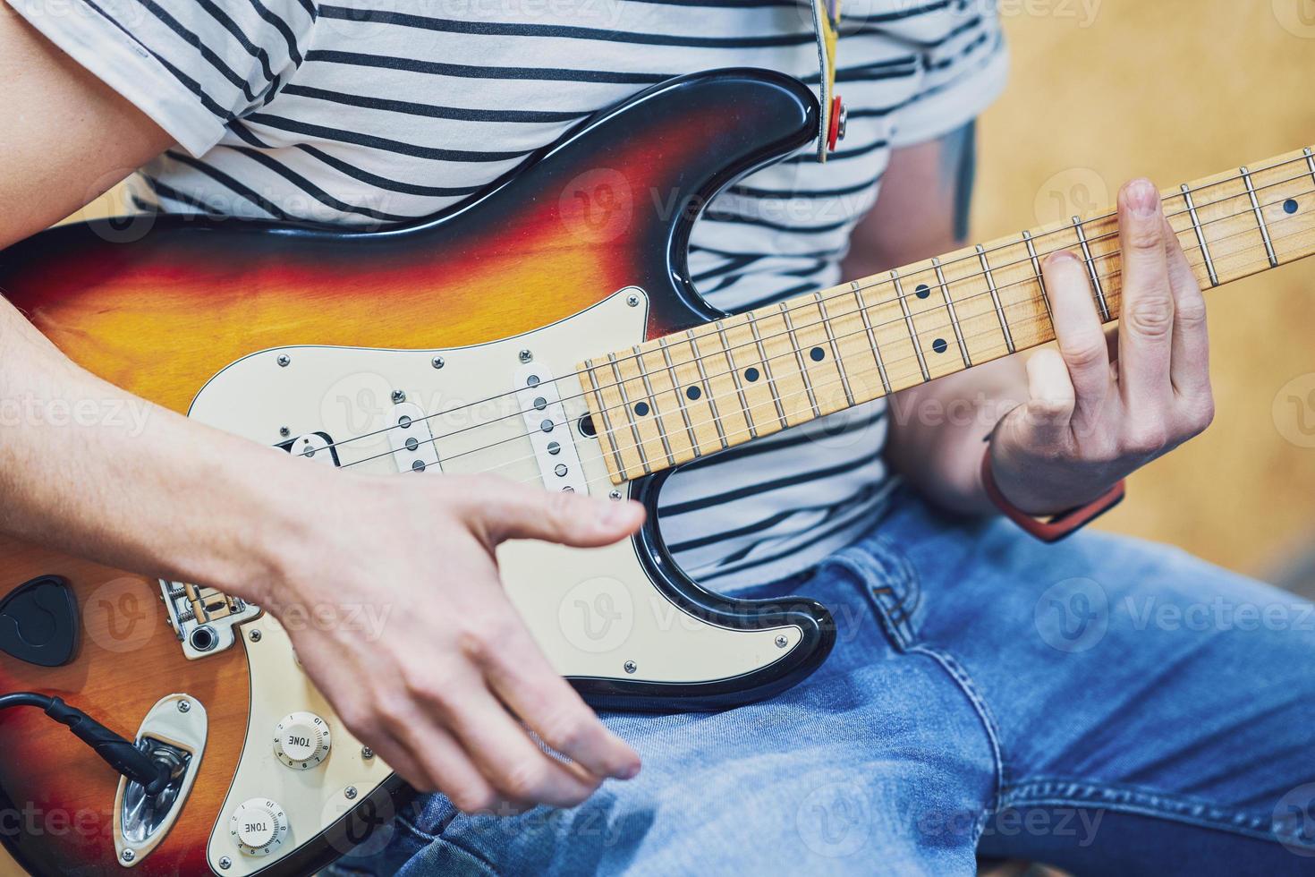 Handsome man playing guitar in studio photo