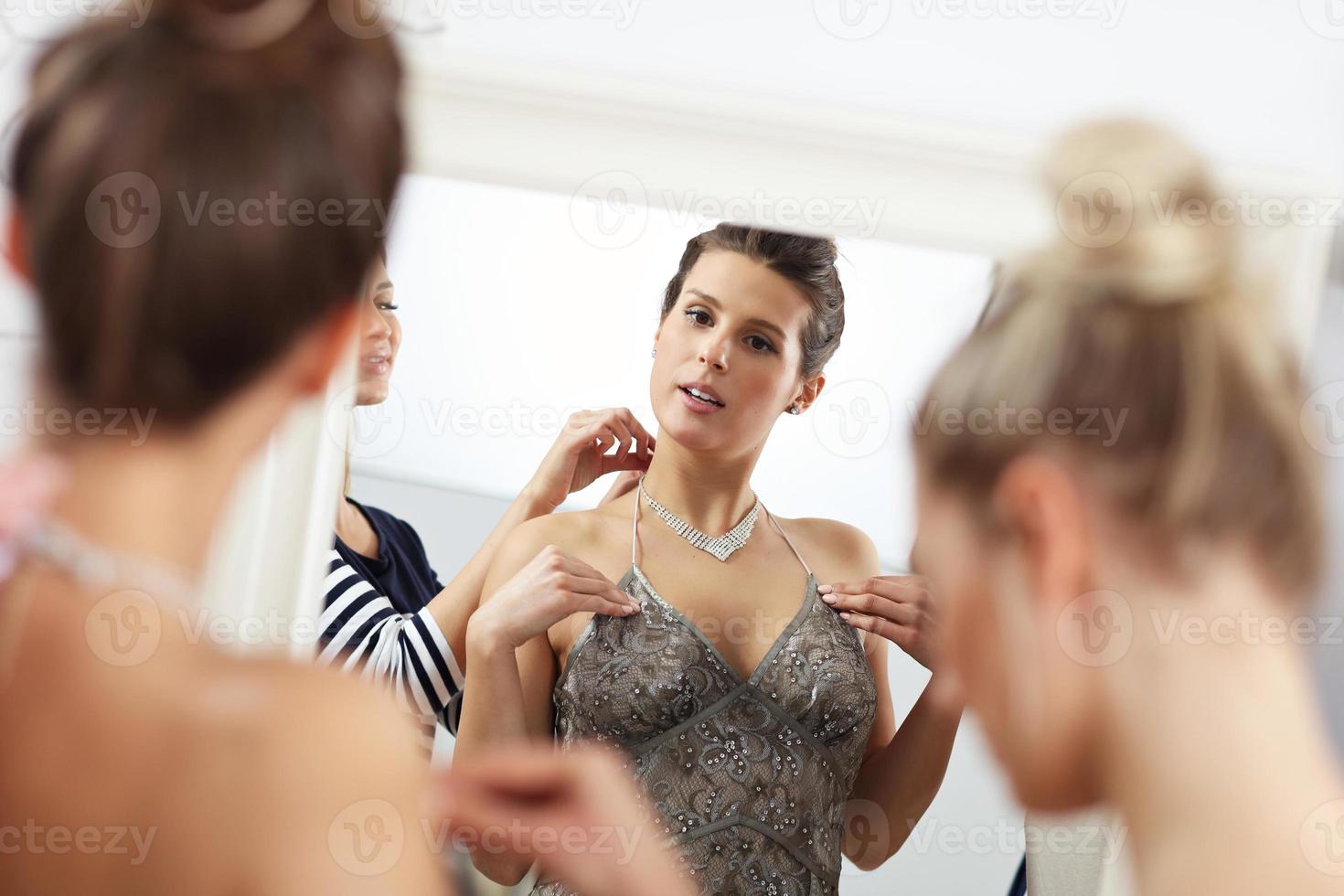 mujer feliz probándose un vestido en la tienda foto