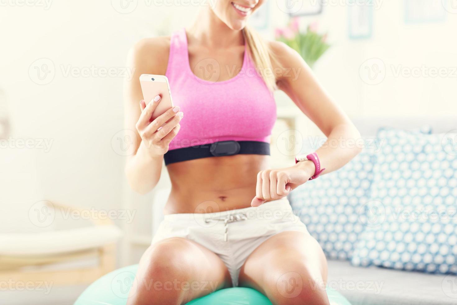 Sports woman using smart watch and checking her heart rate photo