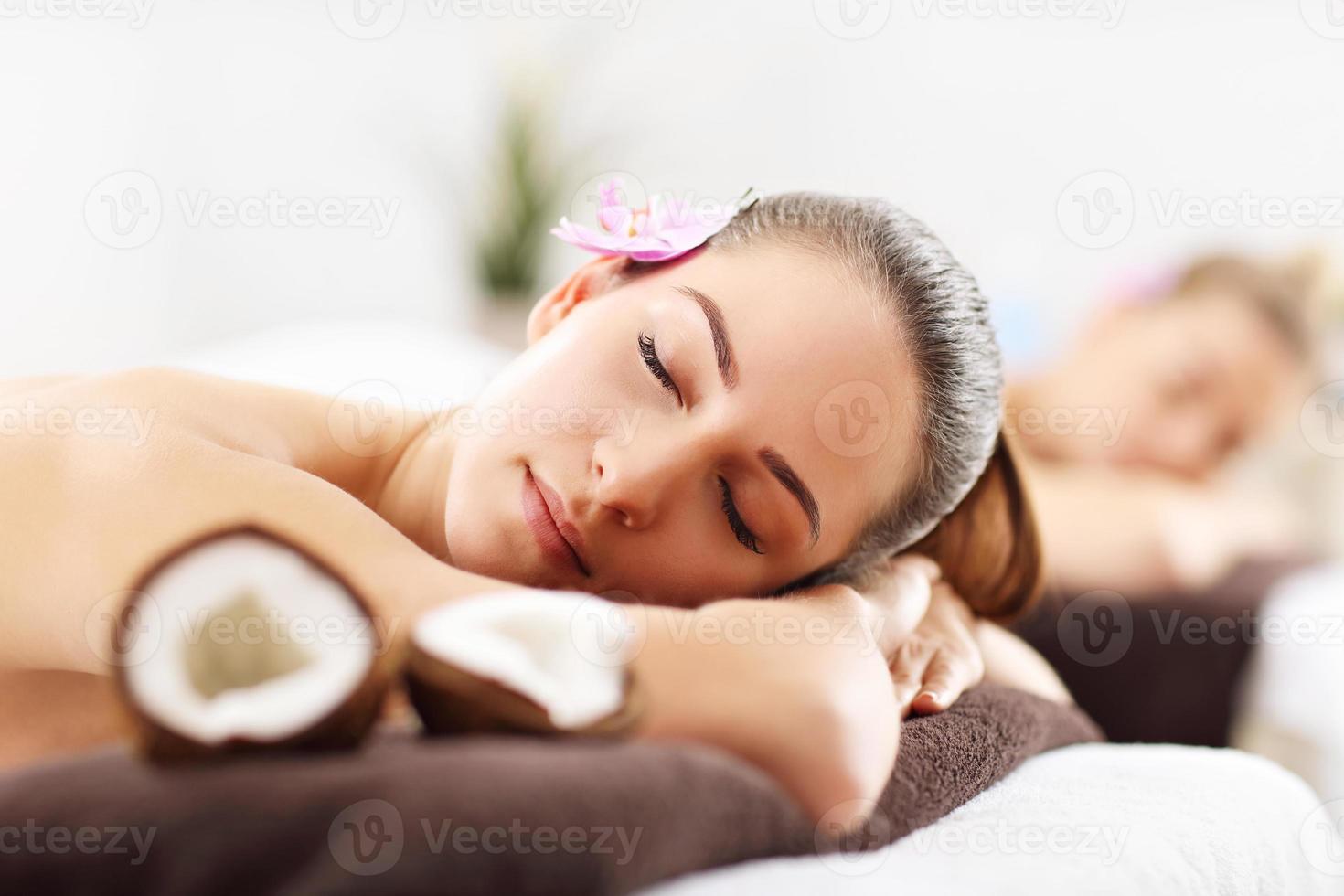 dos hermosas mujeres recibiendo masajes en el spa foto