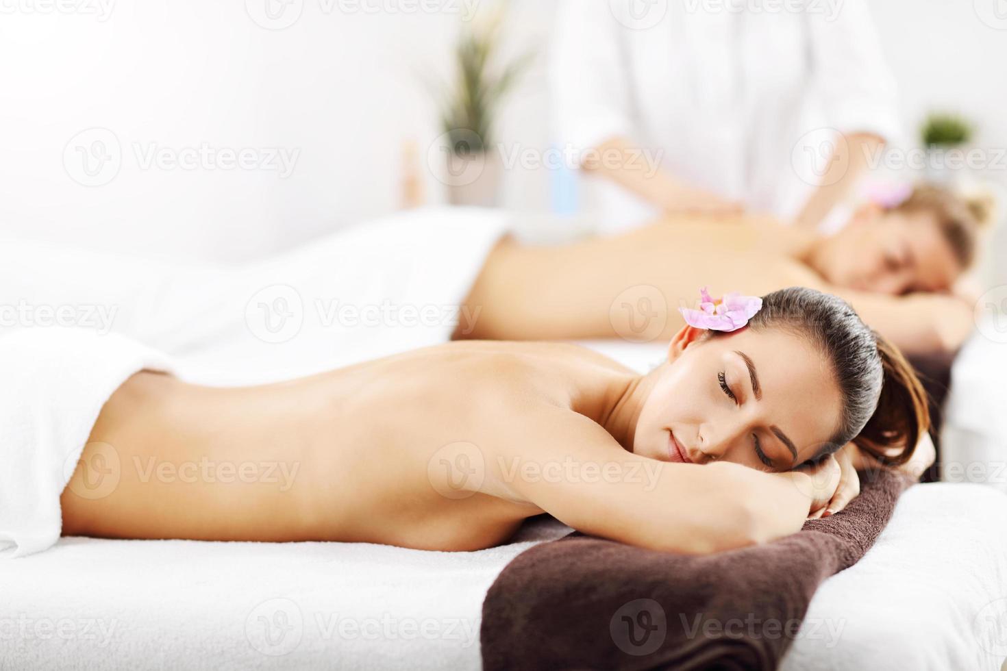 Two beautiful women getting massage in spa photo