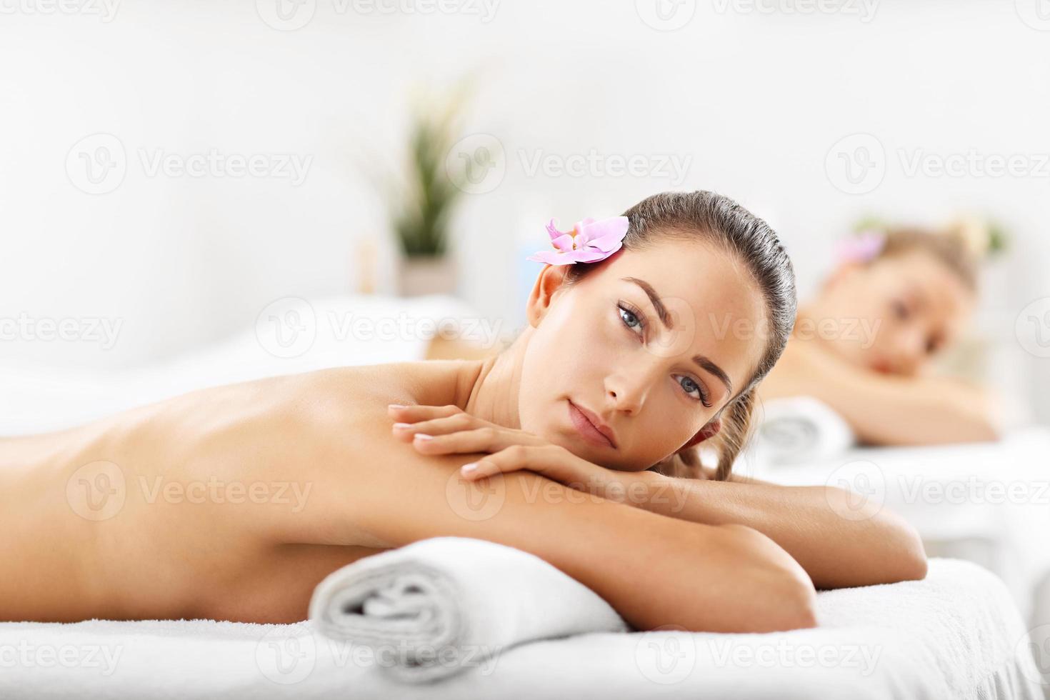 Two beautiful women getting massage in spa photo