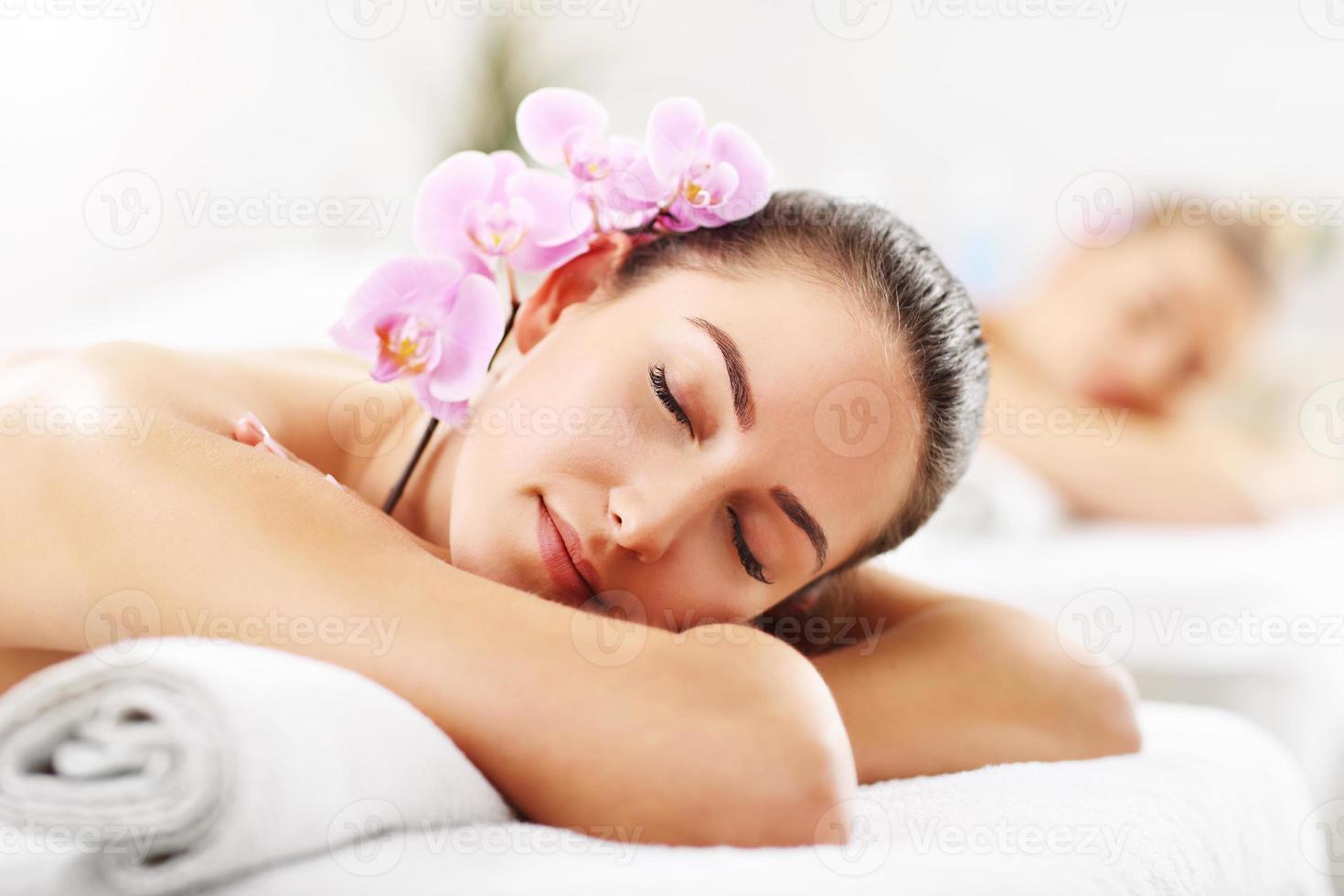 Two beautiful women getting massage in spa photo