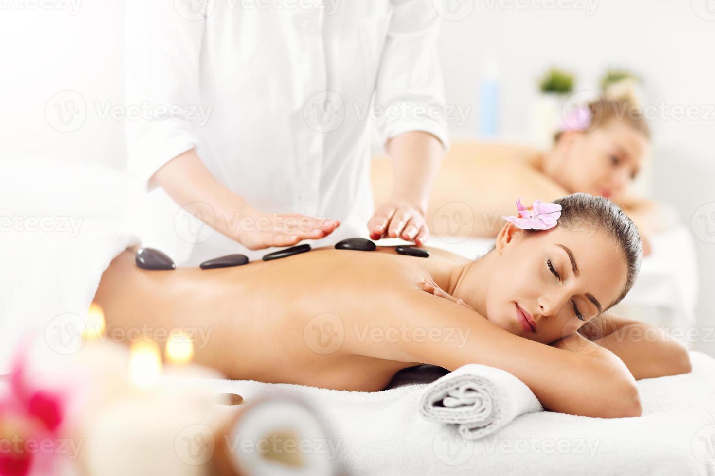 Two beautiful women getting massage in spa photo