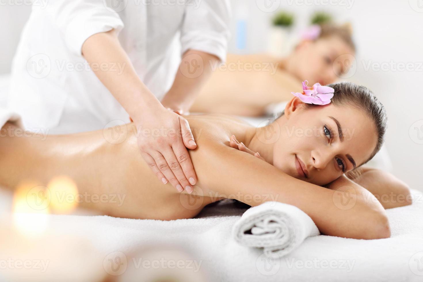 Two beautiful women getting massage in spa photo