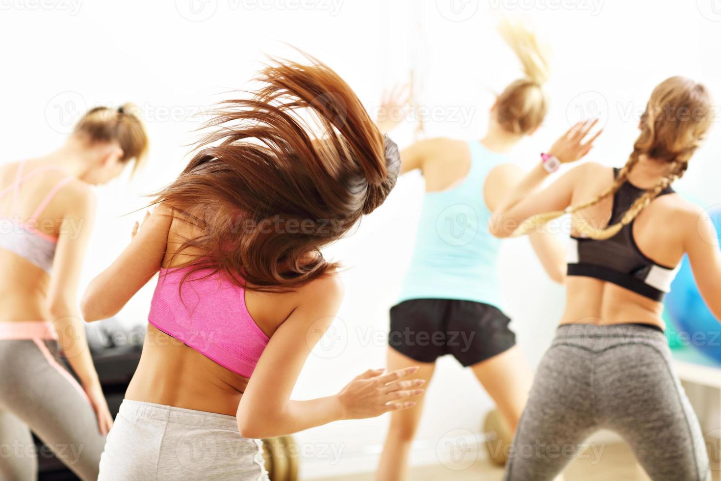 grupo de gente feliz con entrenador bailando en el gimnasio foto