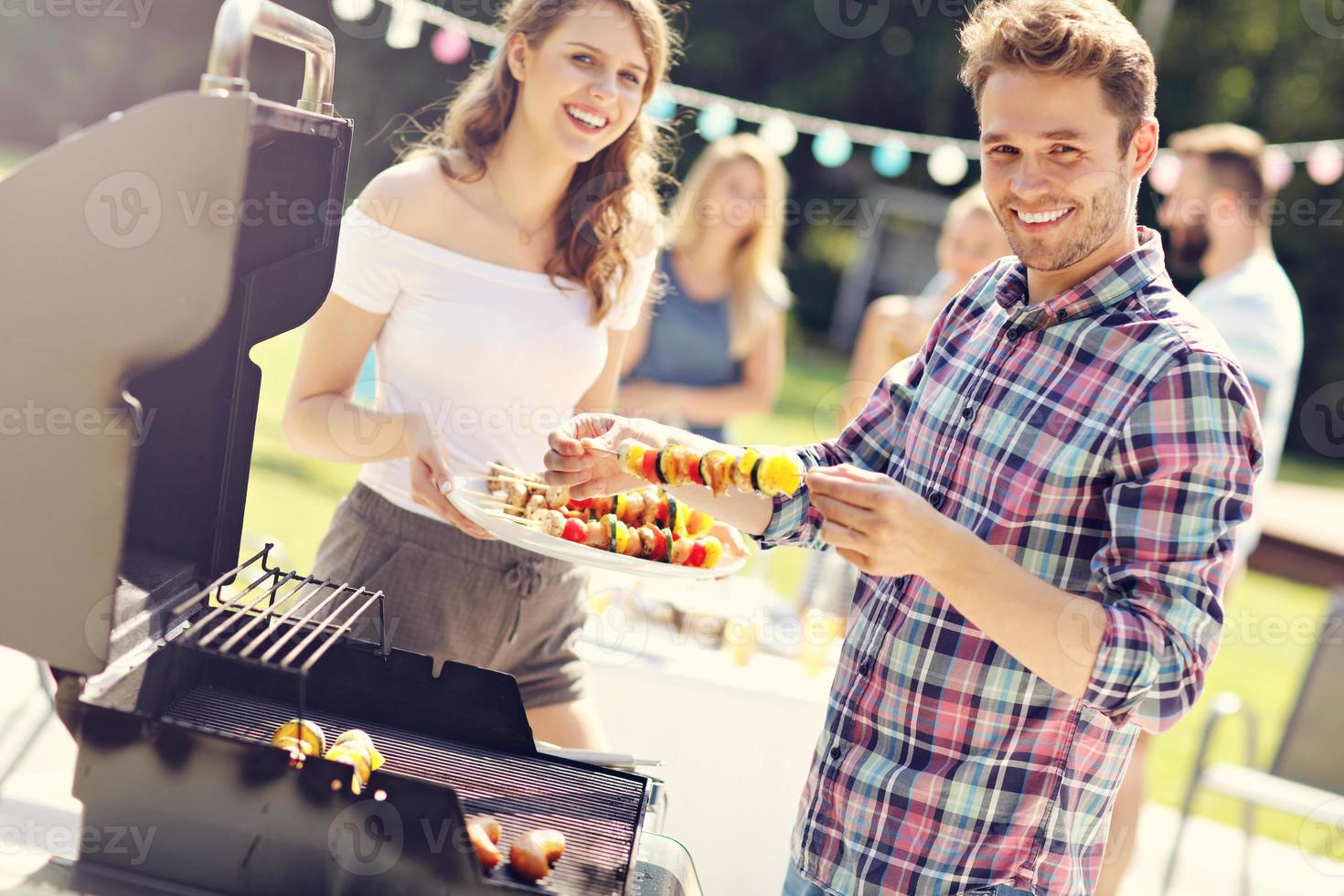 Friends having barbecue party in backyard photo