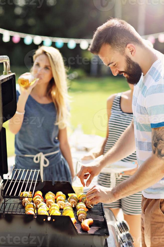 Friends having barbecue party in backyard photo