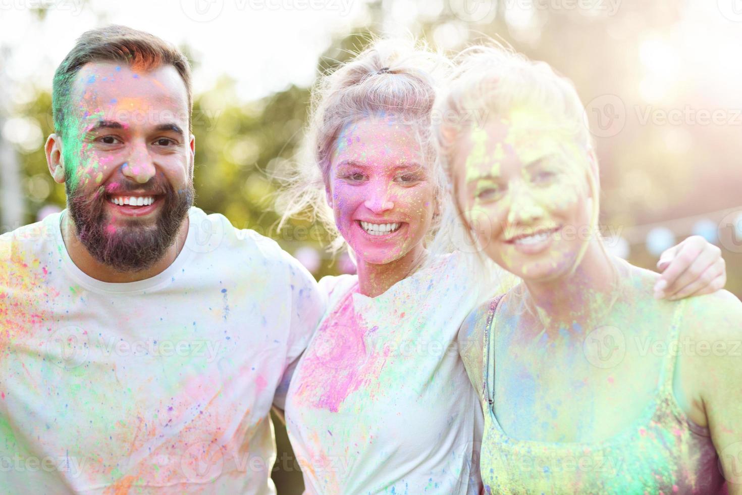 Group of friends having fun at color festival photo