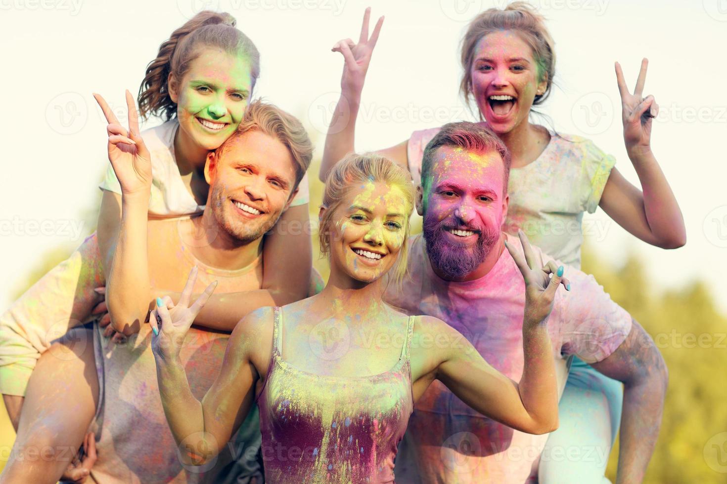 Group of friends having fun at color festival photo